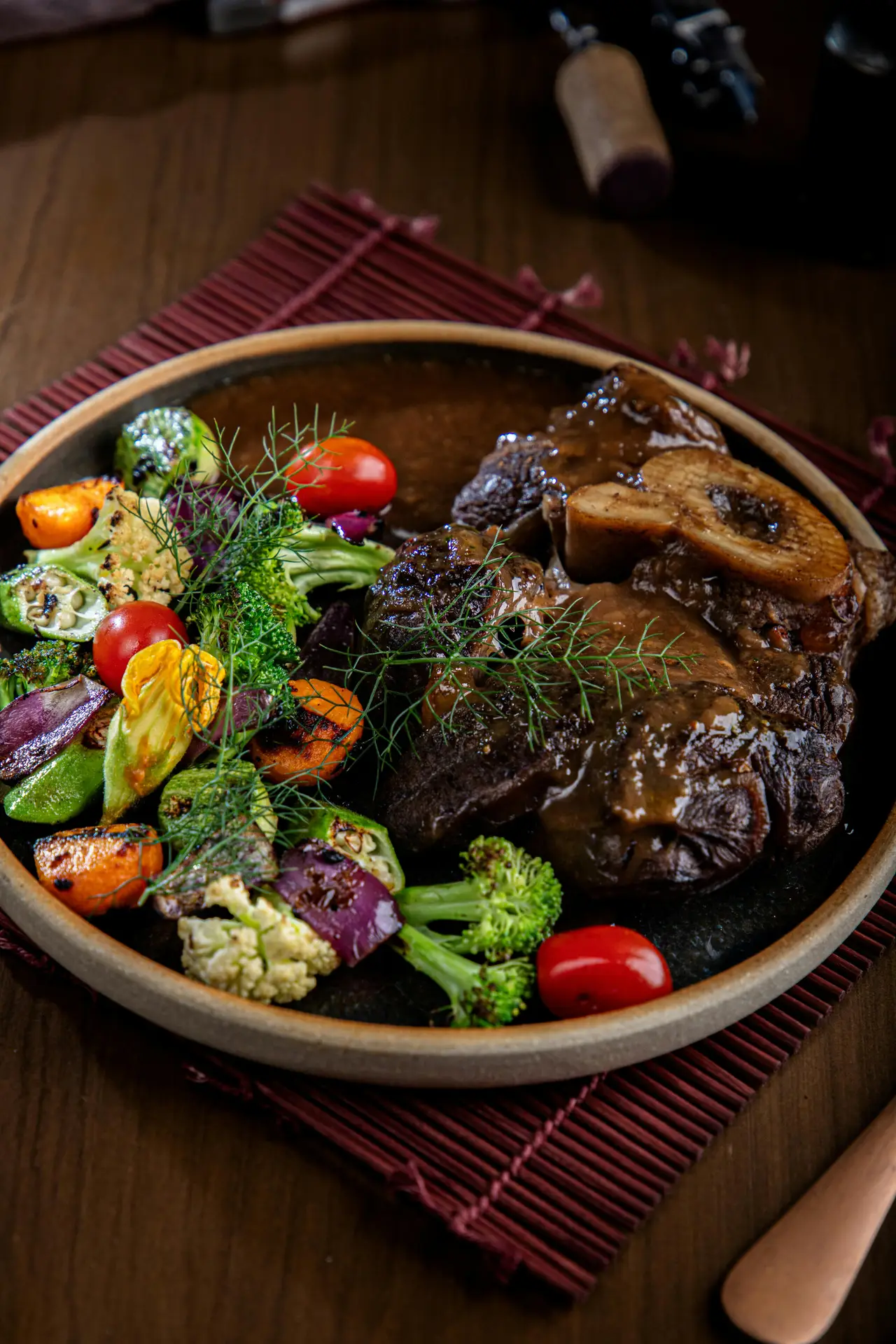Succulent Osso Buco served with vibrant roasted vegetables captures a gourmet experience.